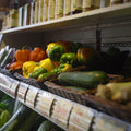 Fresh produce displayed in baskets, including cucumbers, peppers, and other fresh grocery items.
